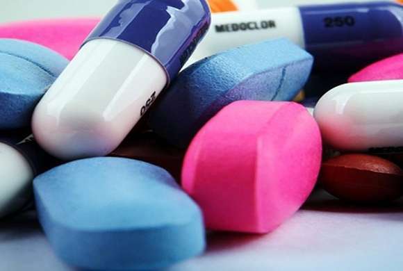 Mix de medicamentos com comprimido azul, cápsula azul escuro e branco, cápsula pink 