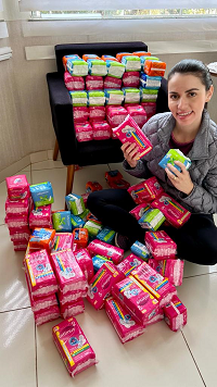 Apresentadora de TV e blogueira Patrícia Helena, que comanda o programa ‘Mulheres Maravilha’, com alguns dos absorventes arrecadados em sua campanha, que serviu como inspiração a Campanha Farmácia Solidária - Produtos de Higiene.