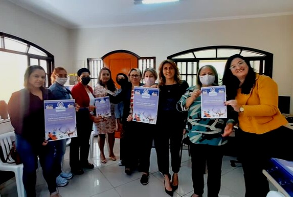 Representantes do Conselho Municipal dos Direitos da Mulher com os cartazes da Campanha Farmácia Solidária - Produtos de Higiene