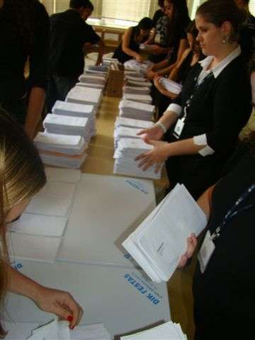 Funcionários separam por seção eleitoral os envelopes com os votos por correspondência