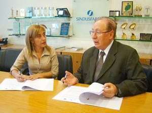 Dra. Raquel Rizzi e o professor Lauro Moretto assinam termo de cooperação na sede do Sindusfarma